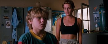 Movie still from “Free Willy” (1993), directed by Simon Wincer – A woman and a young boy standing next to each other in a room; Medium shot, Low angle