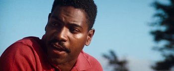 Movie still from “Free Willy” (1993), directed by Simon Wincer – A person wearing a red shirt; Close Up shot, Low angle