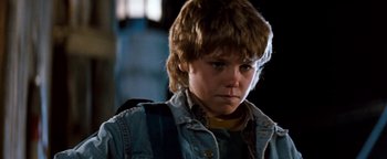 Movie still from “Free Willy” (1993), directed by Simon Wincer – A young boy with a backpack looking at the camera; Close Up shot, Low angle