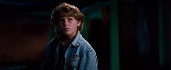 Movie still from “Free Willy” (1993), directed by Simon Wincer – A young boy in a denim jacket looking at the camera; Close Up shot, Low angle