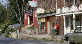 Movie still from “Friday the 13th” (1980), directed by Sean S. Cunningham – Two people walking down the sidewalk in front of a building; Extreme Wide shot, High angle
