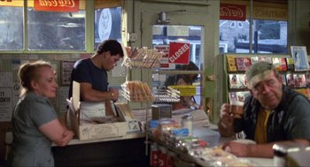 Movie still from “Friday the 13th” (1980), directed by Sean S. Cunningham – A man working in a donut shop with other people in the background; Medium shot, Over the shoulder angle
