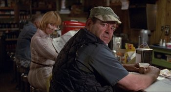 Movie still from “Friday the 13th” (1980), directed by Sean S. Cunningham – A man and a woman are sitting at a table; Medium shot, Over the shoulder angle