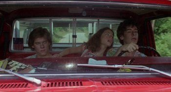 Movie still from “Friday the 13th” (1980), directed by Sean S. Cunningham – Three people in a red car looking out the window; Medium shot, High angle