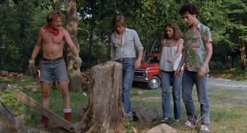 Movie still from “Friday the 13th” (1980), directed by Sean S. Cunningham – A group of young people standing next to a tree stump; Wide shot, Low angle