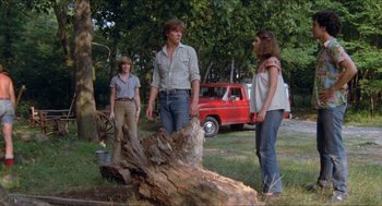 Movie still from “Friday the 13th” (1980), directed by Sean S. Cunningham – A group of people standing next to a tree stump; Wide shot, Low angle