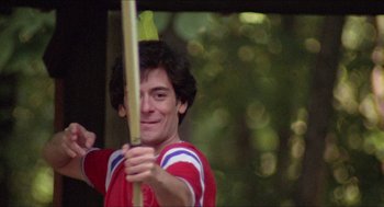 Movie still from “Friday the 13th” (1980), directed by Sean S. Cunningham – A man holding a bow and arrow in the woods; Medium shot, Low angle