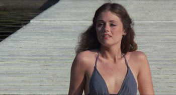 Movie still from “Friday the 13th” (1980), directed by Sean S. Cunningham – A beautiful woman in a blue bathing suit standing next to a staircase; Close Up shot, High angle