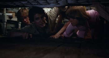 Movie still from “Friday the 13th” (1980), directed by Sean S. Cunningham – A group of young people under a blanket; Medium shot, High angle