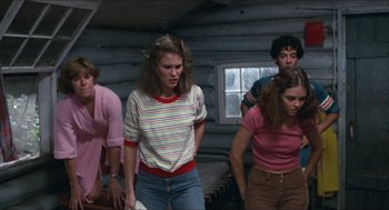 Movie still from “Friday the 13th” (1980), directed by Sean S. Cunningham – A group of people standing around in a room together; Medium shot, Low angle