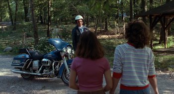 Movie still from “Friday the 13th” (1980), directed by Sean S. Cunningham – A man standing next to a motorcycle in the woods; Wide shot, Over the shoulder angle