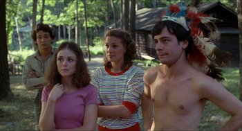Movie still from “Friday the 13th” (1980), directed by Sean S. Cunningham – A group of people standing next to each other in a forest; Medium shot, Over the shoulder angle