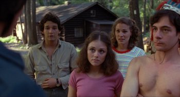 Movie still from “Friday the 13th” (1980), directed by Sean S. Cunningham – A group of people standing next to each other in front of a cabin; Medium shot, Over the shoulder angle