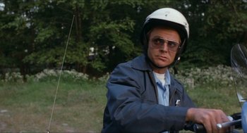 Movie still from “Friday the 13th” (1980), directed by Sean S. Cunningham – A man wearing a helmet while riding a scooter; Medium shot, Low angle