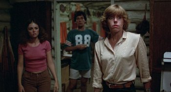 Movie still from “Friday the 13th” (1980), directed by Sean S. Cunningham – A group of people standing in front of a building; Medium shot, Low angle