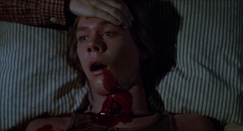 Movie still from “Friday the 13th” (1980), directed by Sean S. Cunningham – A person with a knife in their mouth; Close Up shot, Overhead angle