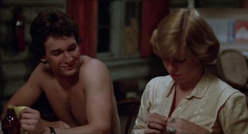 Movie still from “Friday the 13th” (1980), directed by Sean S. Cunningham – A man and a woman sitting next to each other in a room; Medium shot, Over the shoulder angle