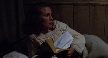 Movie still from “Friday the 13th” (1980), directed by Sean S. Cunningham – A young woman is reading a book in the dark; Medium shot, High angle