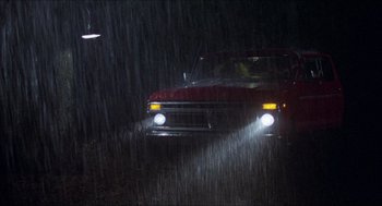 Movie still from “Friday the 13th” (1980), directed by Sean S. Cunningham – A red pickup truck driving in the rain; Extreme Wide shot, Low angle