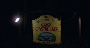 Movie still from “Friday the 13th” (1980), directed by Sean S. Cunningham – A sign that reads " welcome to camp crystal lake "; Wide shot, Low angle