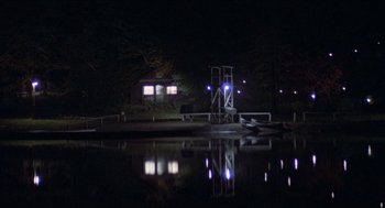 Movie still from “Friday the 13th” (1980), directed by Sean S. Cunningham – A dock with lights on a lake at night time; Extreme Wide shot, High angle
