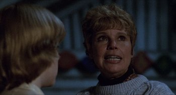 Movie still from “Friday the 13th” (1980), directed by Sean S. Cunningham – An older woman talking to a young boy in front of a building; Close Up shot, Over the shoulder angle