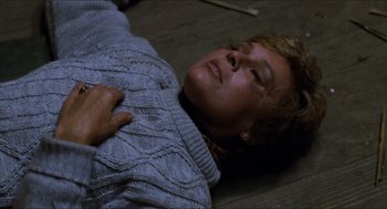 Movie still from “Friday the 13th” (1980), directed by Sean S. Cunningham – A person laying on the ground wearing a sweater; Close Up shot, High angle