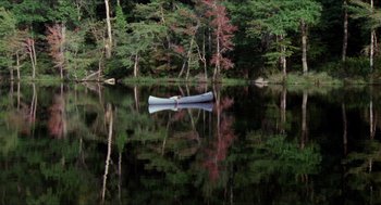 Movie still from “Friday the 13th” (1980), directed by Sean S. Cunningham – A white canoe on a lake surrounded by trees; Extreme Wide shot, High angle
