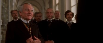 Movie still from “From Hell” (2001), directed by Allen Hughes – A group of men standing next to each other in a room; Medium shot, Low angle