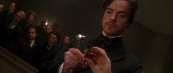 Movie still from “From Hell” (2001), directed by Allen Hughes – A man in a black suit holding a pipe in his hand; Close Up shot, Low angle