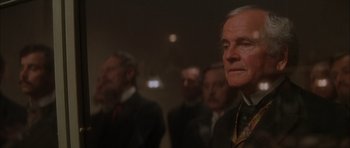 Movie still from “From Hell” (2001), directed by Allen Hughes – A group of men standing next to each other in a room; Close Up shot, Over the shoulder angle