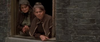 Movie still from “From Hell” (2001), directed by Allen Hughes – An older woman looking out of a window; Medium shot, Low angle