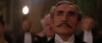 Movie still from “From Hell” (2001), directed by Allen Hughes – An older man with a mustache and a mustache stand in front of a group of people; Close Up shot, Low angle