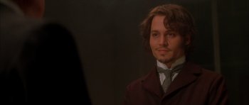 Movie still from “From Hell” (2001), directed by Allen Hughes – A man with long brown hair wearing a suit and tie; Close Up shot, Over the shoulder angle