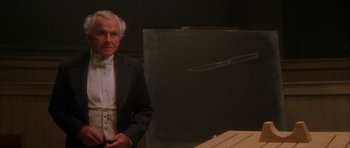 Movie still from “From Hell” (2001), directed by Allen Hughes – An older man in a tuxedo sitting in front of an easel; Close Up shot, High angle