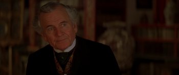 Movie still from “From Hell” (2001), directed by Allen Hughes – An older man wearing a suit and tie; Close Up shot, Over the shoulder angle