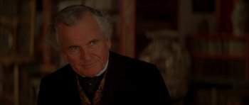 Movie still from “From Hell” (2001), directed by Allen Hughes – An older man wearing a suit and tie; Close Up shot, Over the shoulder angle