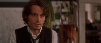 Movie still from “From Hell” (2001), directed by Allen Hughes – A man with long brown hair wearing a black vest; Close Up shot, Over the shoulder angle