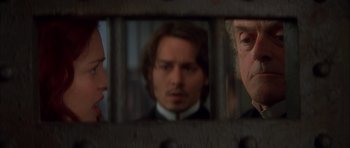 Movie still from “From Hell” (2001), directed by Allen Hughes – A man and a woman looking at each other through a fence; Close Up shot, Over the shoulder angle