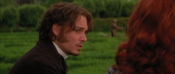 Movie still from “From Hell” (2001), directed by Allen Hughes – A man with long brown hair and a beard looking to his left; Close Up shot, Over the shoulder angle