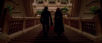 Movie still from “From Hell” (2001), directed by Allen Hughes – A man and a woman walking up a set of stairs; Wide shot, Low angle