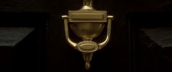 Movie still from “From Hell” (2001), directed by Allen Hughes – A door knocker on a black door; Extreme Close Up shot, Overhead angle