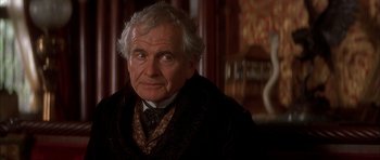 Movie still from “From Hell” (2001), directed by Allen Hughes – An older man in a suit and tie looking at the camera; Close Up shot, Over the shoulder angle