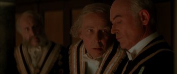 Movie still from “From Hell” (2001), directed by Allen Hughes – A man and a bald man looking at one another; Close Up shot, Over the shoulder angle