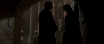 Movie still from “From Hell” (2001), directed by Allen Hughes – A man and a woman standing next to each other in the dark; Medium shot, Low angle