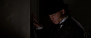 Movie still from “From Hell” (2001), directed by Allen Hughes – A man wearing a black hat and a black suit; Close Up shot, Low angle