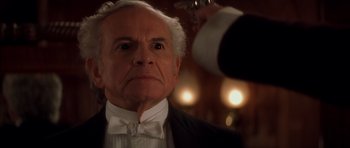 Movie still from “From Hell” (2001), directed by Allen Hughes – An older man in a tuxedo looking at the camera; Close Up shot, Low angle