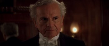 Movie still from “From Hell” (2001), directed by Allen Hughes – An older man wearing a tuxedo and a bow tie; Close Up shot, Over the shoulder angle