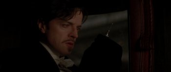 Movie still from “From Hell” (2001), directed by Allen Hughes – A person wearing a suit and tie; Close Up shot, Low angle