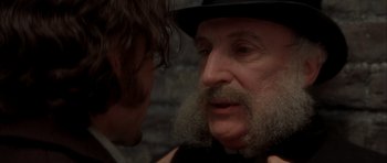Movie still from “From Hell” (2001), directed by Allen Hughes – An old man with a beard and a hat is talking to a young man; Close Up shot, Over the shoulder angle
